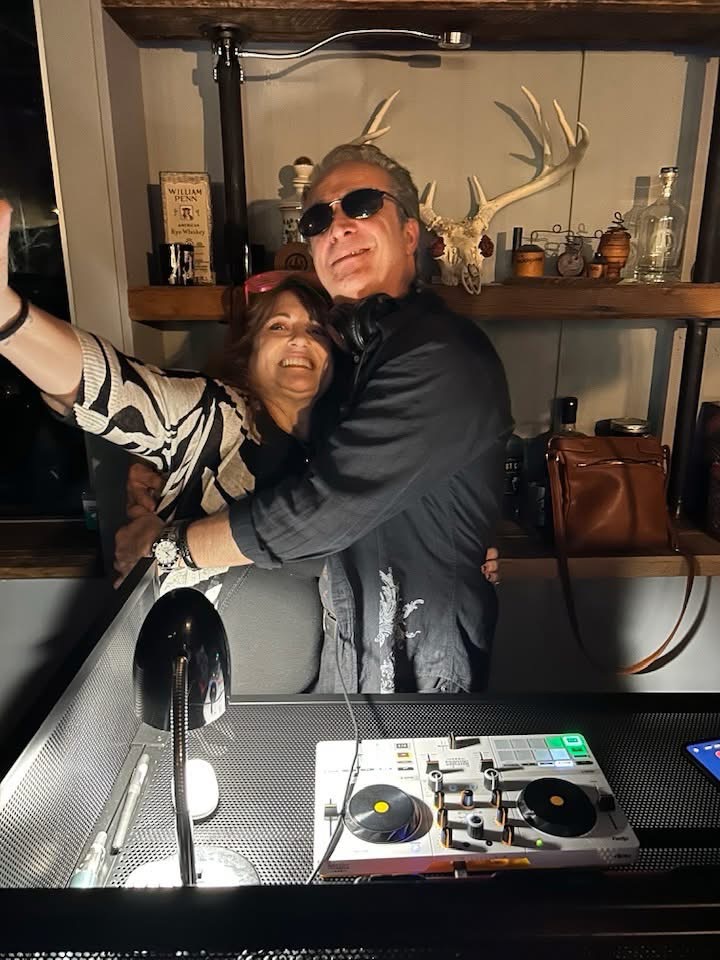 DJ Joe Mancini at the turntables with a guest