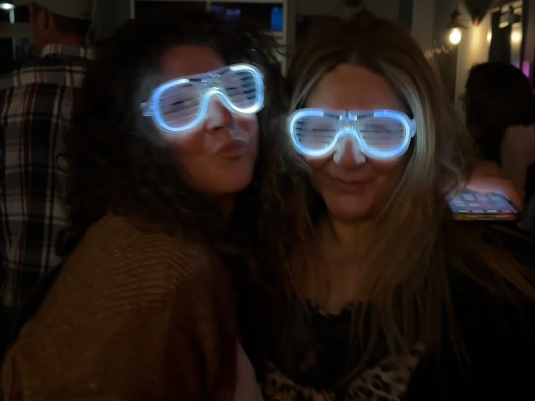 Two friends posing with fun LED glow glasses